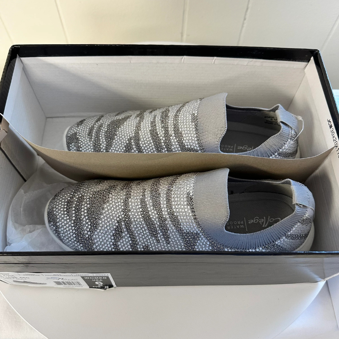 Pair of gray shoes with sequin embellishments in a box.