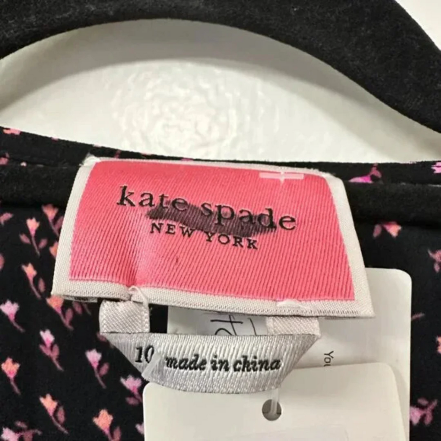 Close-up of a Kate Spade New York label on clothing with 'Made in China' text.