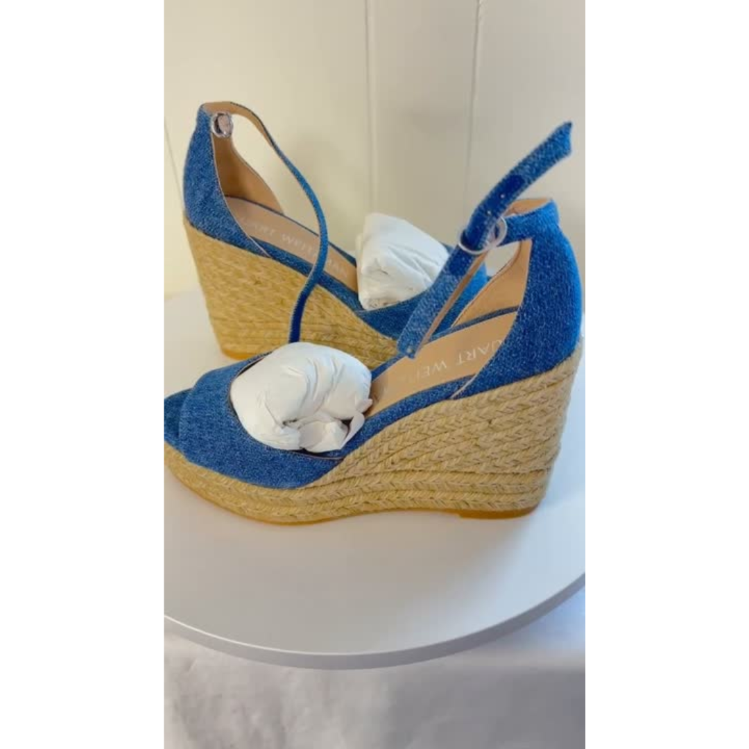 Blue wedge sandals with jute sole on a white surface