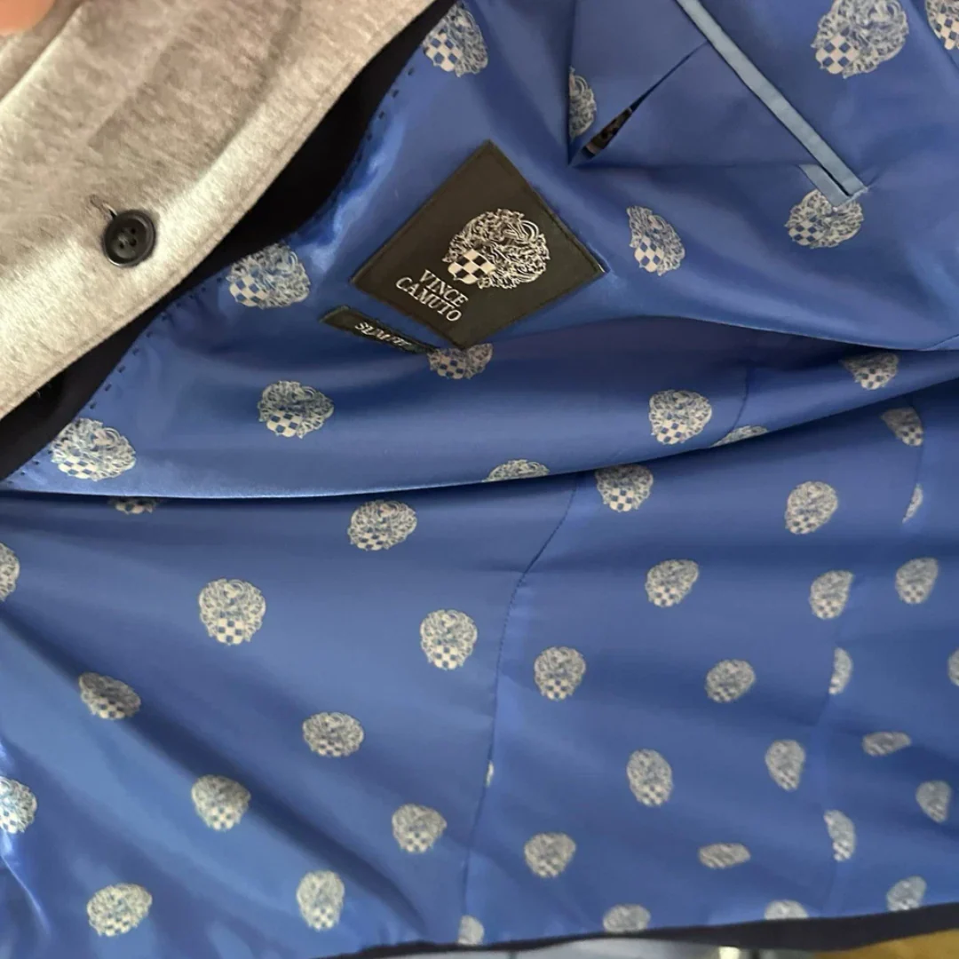Blue fabric lining with silver logo patterns and a brand label on a garment.