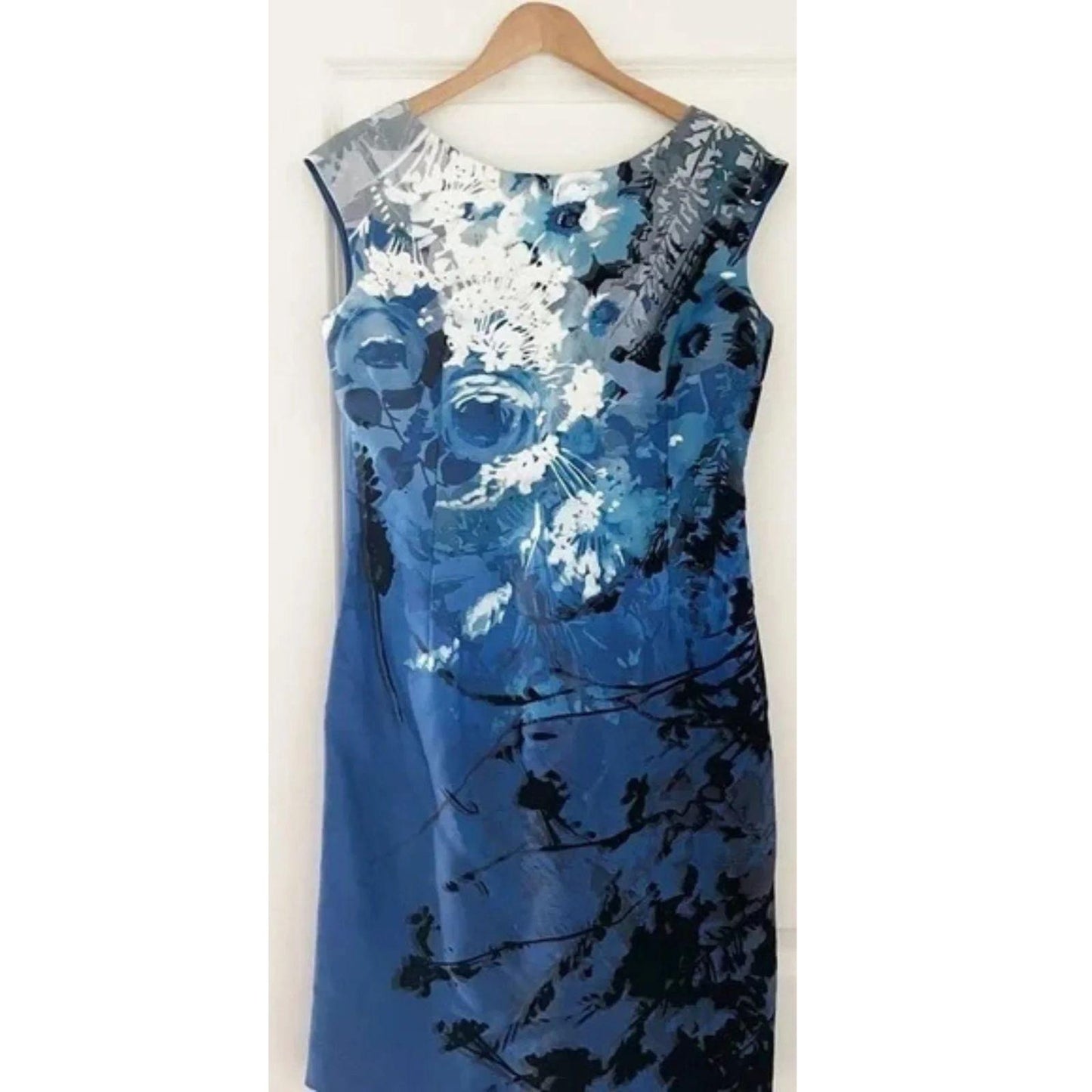 Blue floral dress on a hanger against a white background