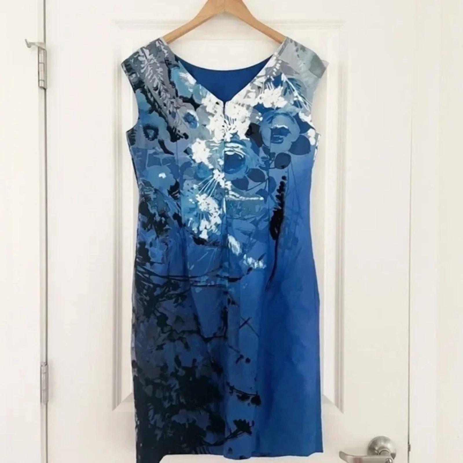 Blue floral dress on a hanger against a white door background