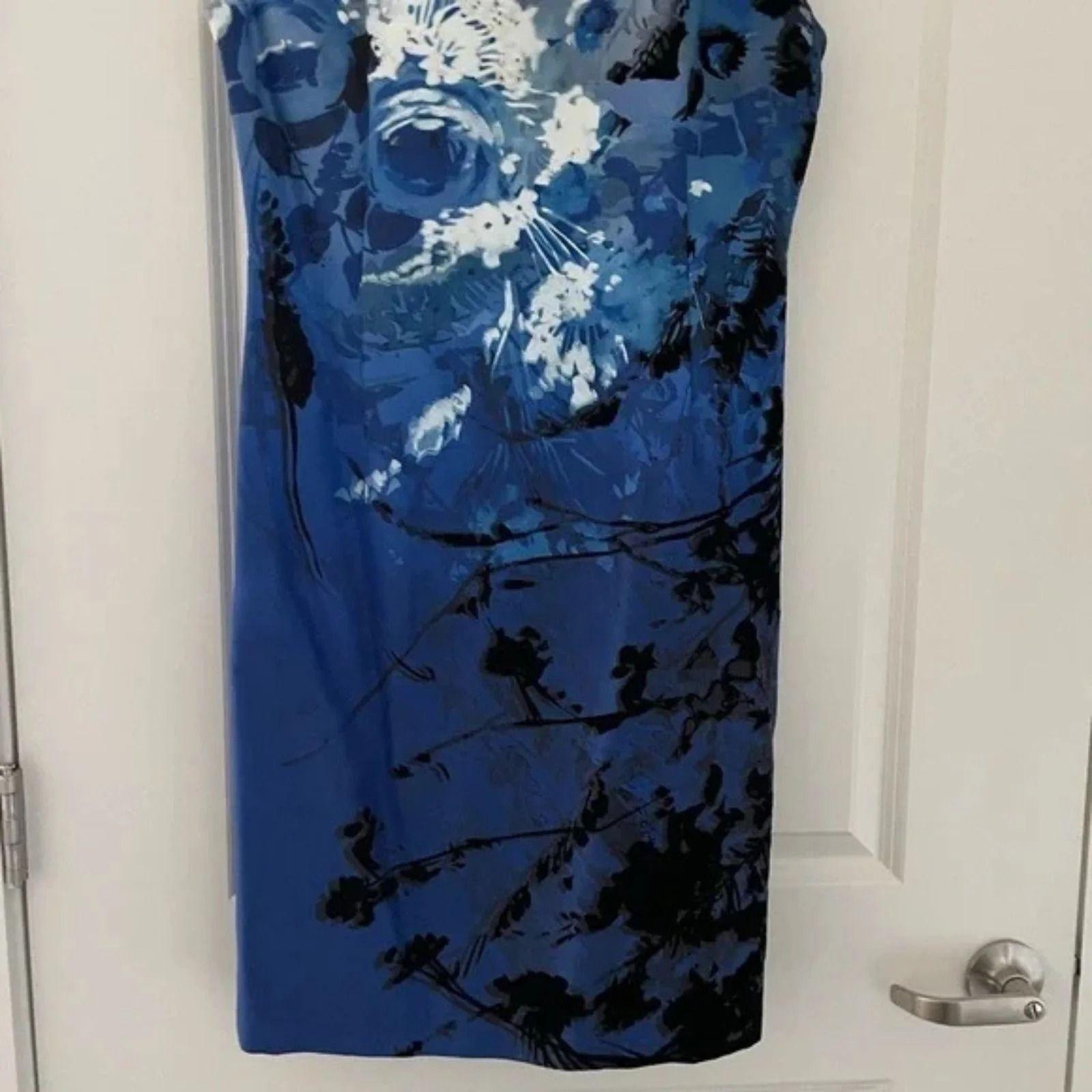 Up close photo showing the lower front of a Blue floral dress hanging on a white door