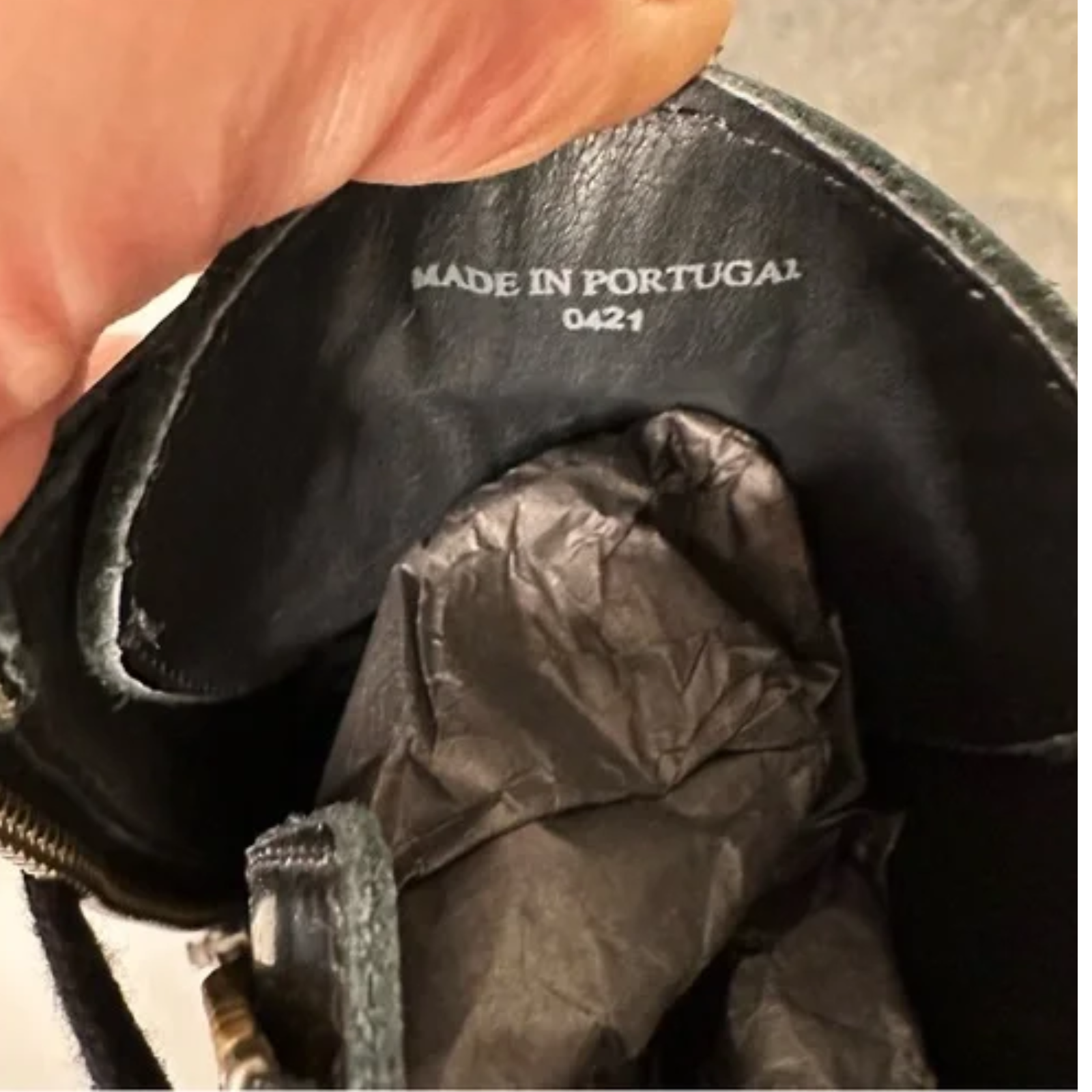 Close-up of a black leather product with 'Made in Portugal' label.