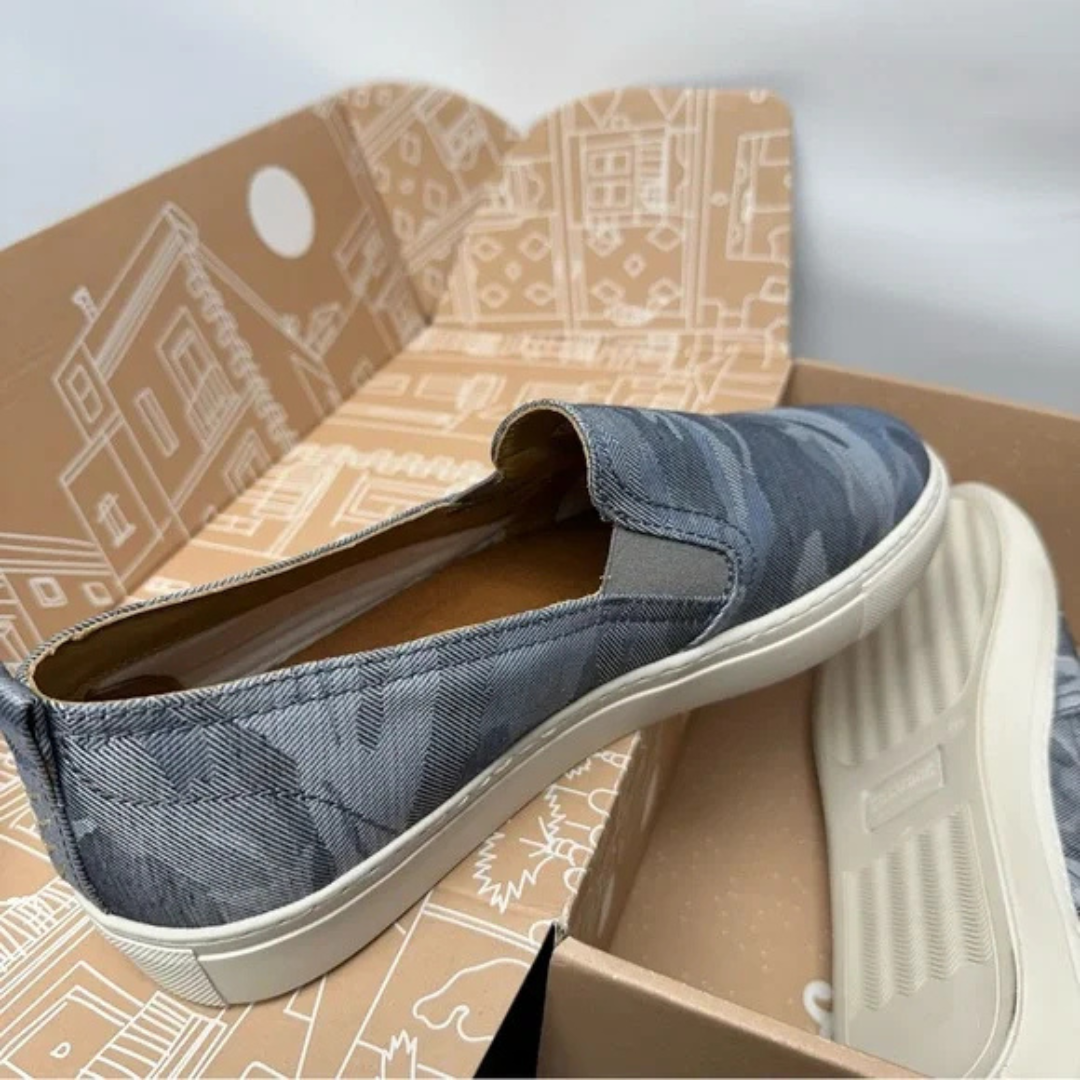 One shoe sitting on top of shoe box and one inside the box