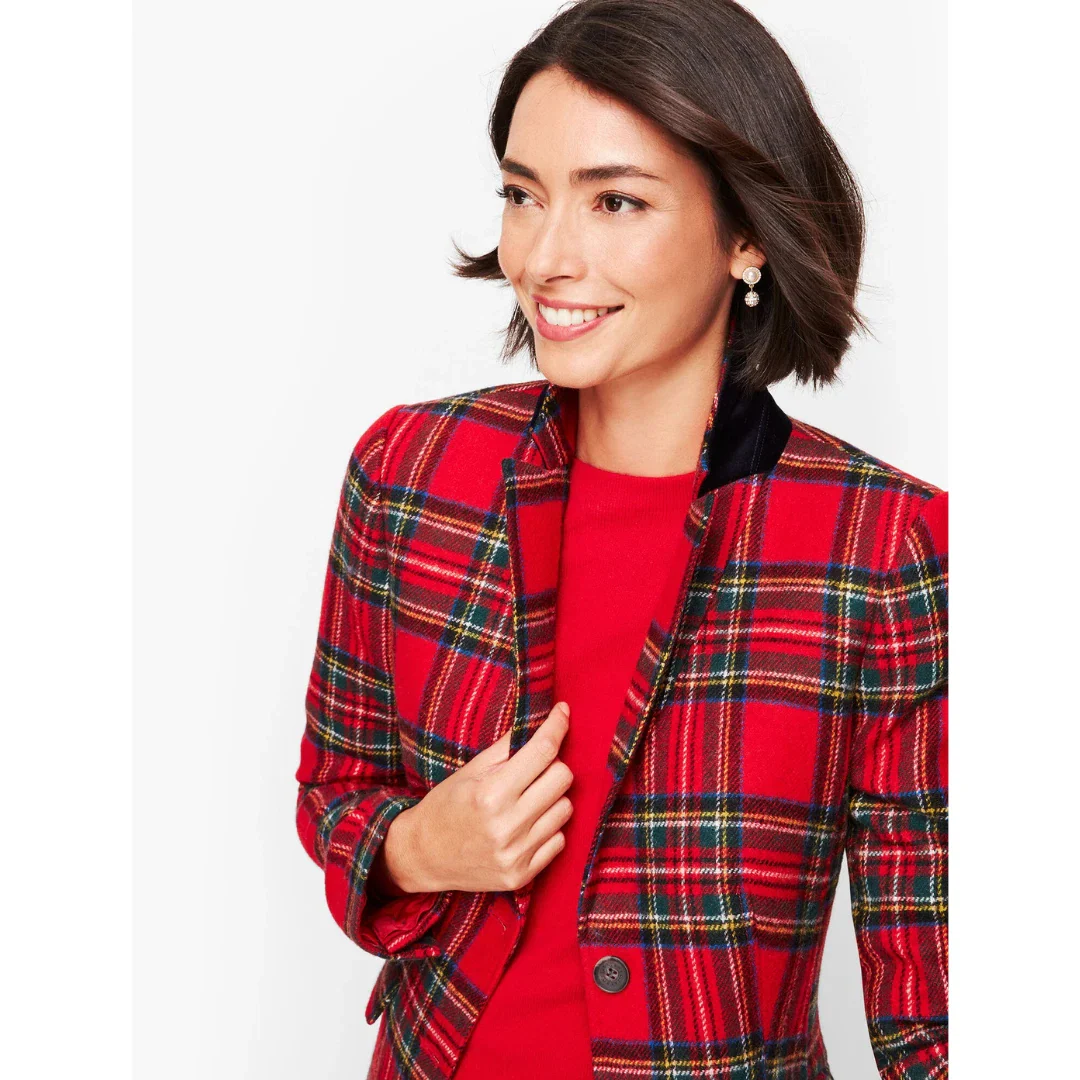 Woman wearing a red plaid blazer with the collar turned up