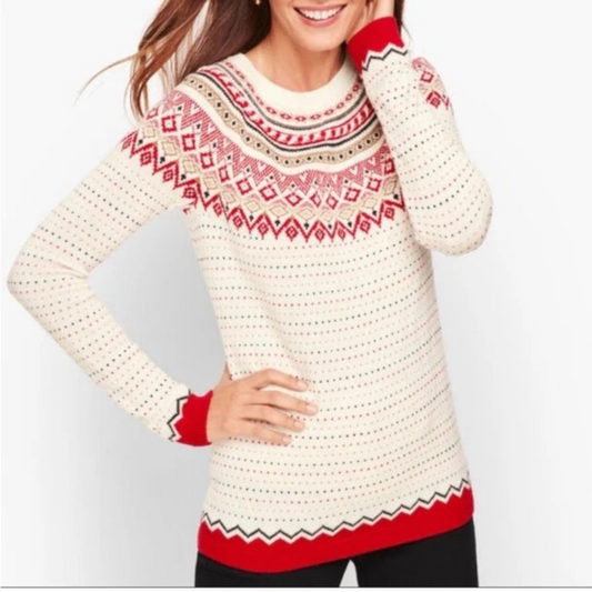 Person wearing a cream sweater with red and black pattern on a white background