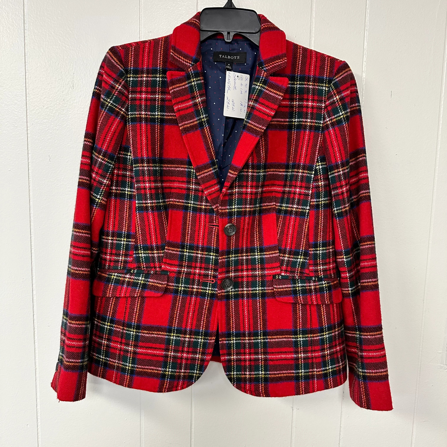 Red plaid blazer on a hanger against a white background