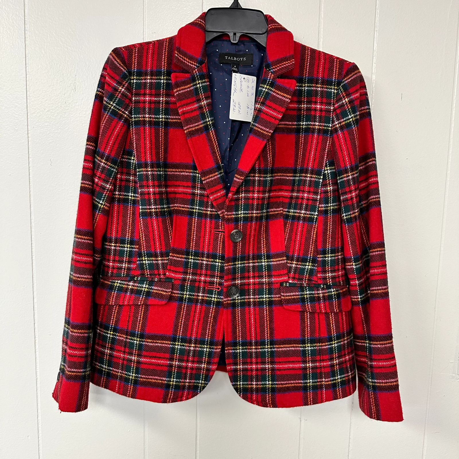 Red plaid blazer on a hanger against a white background