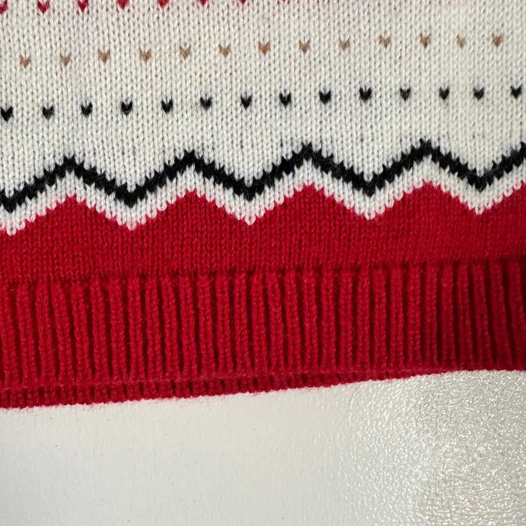 Close-up of a knitted fabric with red, white, and black pattern